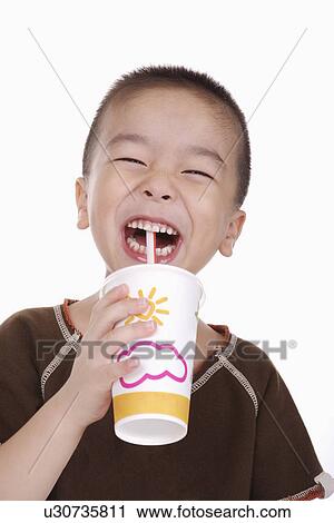 Stock Image - Boy with drink, smiling, portrait. Fotosearch