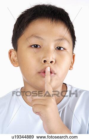 Stock Photo - Boy with Finger on Lips, portrait, close up. Fotosearch