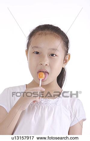 Stock Photo - Girl licking on lollipop, portrait. Fotosearch