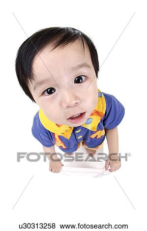 Stock Photo - Girl standing on chair, high angle view, portrait. Fotosearch
