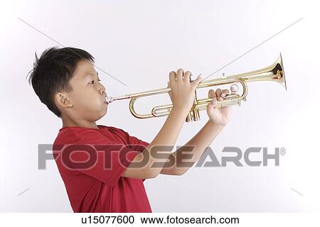 Boy blowing trumpet, side view, portrait View Large Photo Image Stock Image - Boy blowing trumpet, side view, portrait. Fotosearch