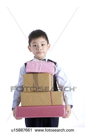 Stock Image - Boy holding stack of gifts. Fotosearch