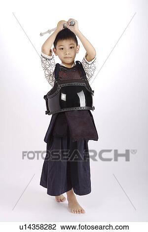 Stock Image - Boy in protective sportswear holding fencing foil. Fotosearch