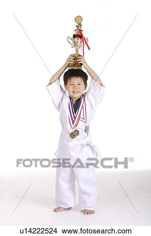 Boy in taekwondo uniform carrying trophy on head View Large Photo Image Picture - Boy in taekwondo uniform carrying trophy on head. Fotosearch