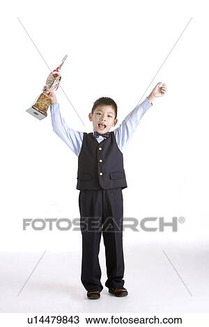 Stock Image - Boy lifting trophy, portrait. Fotosearch