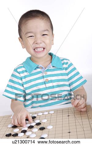 Picture - Boy playing Chinese chess game, Go. Fotosearch