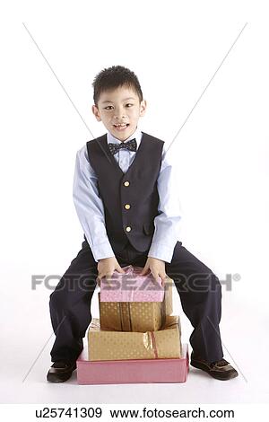 Stock Photo - Boy sitting on stack of gifts. Fotosearch