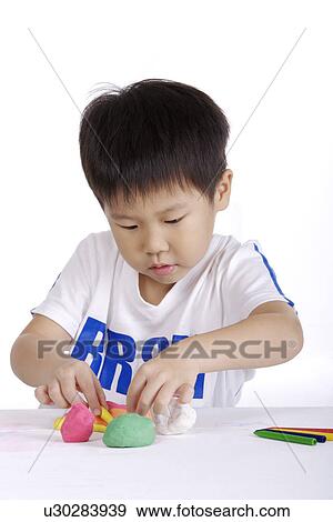 Boy using child's play clay View Large Photo Image Stock Photo - Boy using child's play clay. Fotosearch
