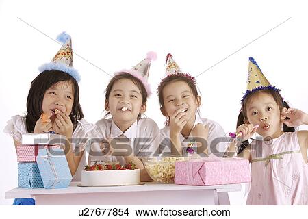 Picture - Four girl smiling, gifts and bowl of popcorn on table. Fotosearch