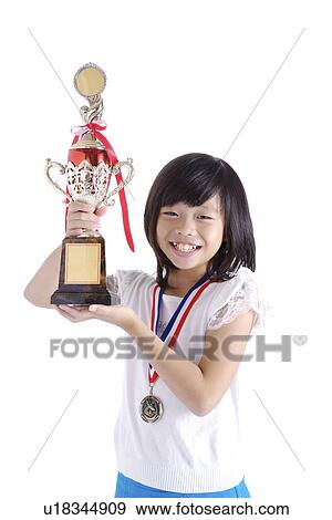 Stock Photo - Girl lifting trophy, portrait. Fotosearch