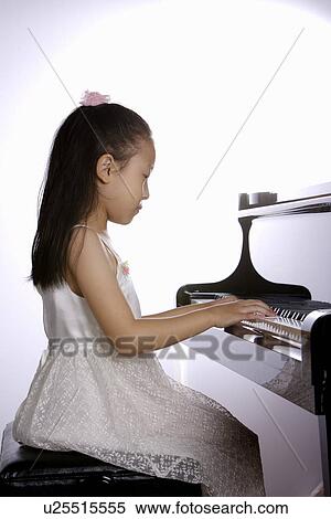 Side profile of a girl playing the piano View Large Photo Image Stock Photography - Side profile of a girl playing the piano. Fotosearch