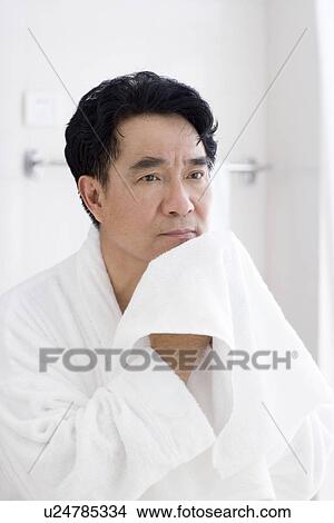 Senior man drying face with towel in bathroom View Large Photo Image Picture - Senior man drying face with towel in bathroom. Fotosearch