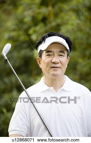 Senior man holding golf club outdoors View Large Photo Image Stock Image - Senior man holding golf club outdoors. Fotosearch