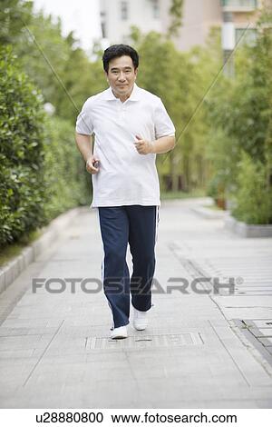 Stock Image - Senior man jogging in park. Fotosearch