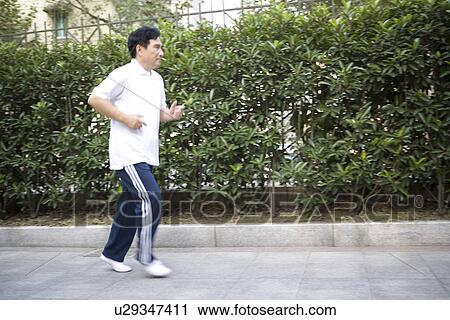 Stock Image - Senior man jogging outdoors. Fotosearch