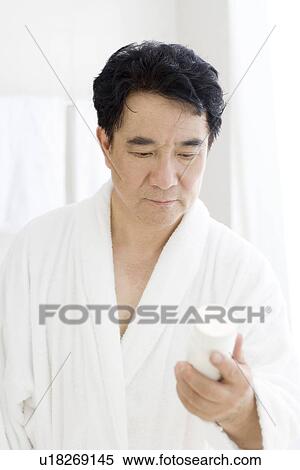 Senior man looking at pill bottle in bathroom View Large Photo Image Stock Photography - Senior man looking at pill bottle in bathroom. Fotosearch