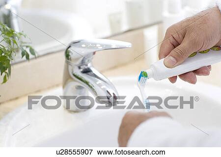 Senior man squeezing toothpaste onto brush, focus on hands View Large Photo Image Stock Photo - Senior man squeezing toothpaste onto brush, focus on hands. Fotosearch