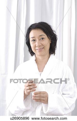 Stock Photograph - Senior woman holding a glass of milk. Fotosearch