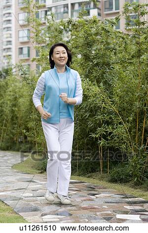 Stock Image - Senior woman jogging outdoors. Fotosearch