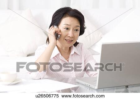 Senior woman on the phone looking laptop View Large Photo Image Stock Photography - Senior woman on the phone looking laptop. Fotosearch