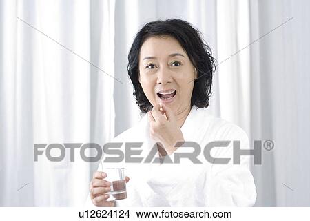 Picture - Senior woman taking medicine, portrait. Fotosearch