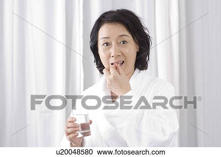 Senior woman taking medicine with water View Large Photo Image Stock Image - Senior woman taking medicine with water. Fotosearch