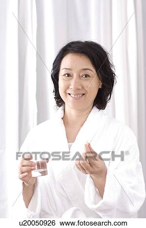 Senior woman taking medicine with water View Large Photo Image Stock Photograph - Senior woman taking medicine with water. Fotosearch