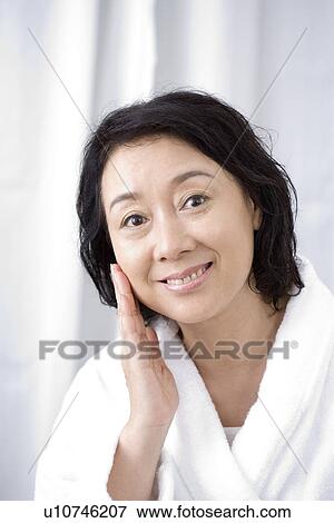 Stock Photo - Senior woman touching face, close up, portrait. Fotosearch