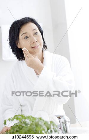 Senior woman using cotton pad on face in bathroom View Large Photo Image Stock Photography - Senior woman using cotton pad on face in bathroom. Fotosearch