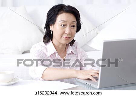Picture - Senior woman using laptop. Fotosearch