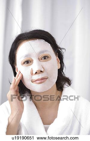 Stock Image - Senior woman with facial mask. Fotosearch