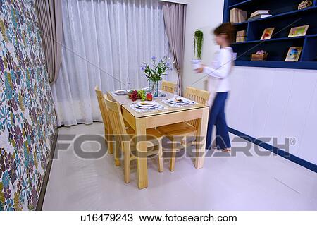 Young woman by dining table View Large Photo Image Stock Image - Young woman by dining table. Fotosearch