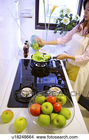 Young woman cooking in kitchen View Large Photo Image Picture - Young woman cooking in kitchen. Fotosearch