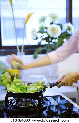Stock Photograph - Young woman cooking in kitchen. Fotosearch