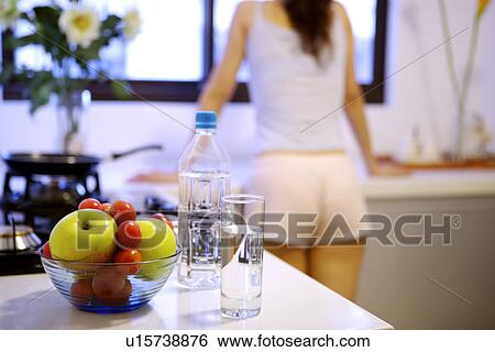 Stock Photograph - Young woman in kitchen, low section. Fotosearch