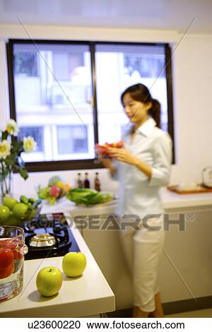 Young woman in kitchen View Large Photo Image Stock Image - Young woman in kitchen. Fotosearch
