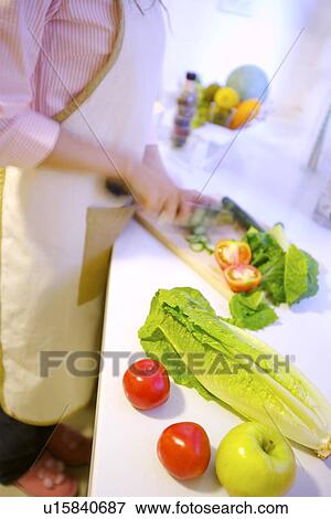 Stock Photo - Young woman preparing for meal. Fotosearch