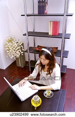Stock Photo - Young woman using laptop. Fotosearch