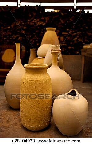 Stock Photo - Clay pots for firing, logs in background. Fotosearch