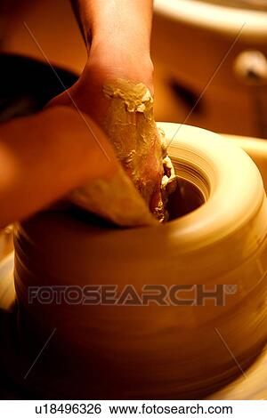 Stock Photograph - Hands of potter at work throwing pot on wheel. Fotosearch
