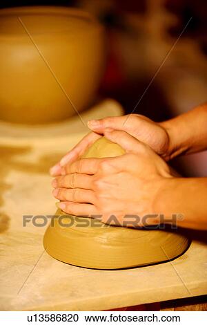 Stock Image - Hands of potter at work throwing pot. Fotosearch