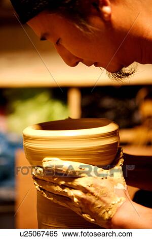 Stock Photography - Potter holding clay body, side view. Fotosearch