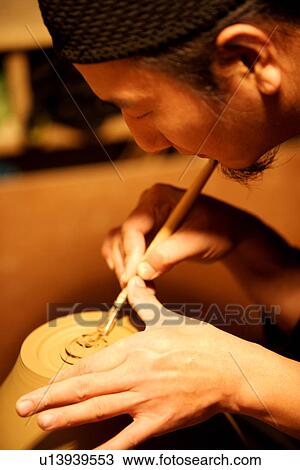 Stock Image - Potter making a vase, carving. Fotosearch