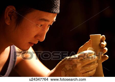 Picture - Potter pinching a vase. Fotosearch