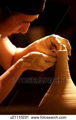 Stock Image - Potter pinching a vase. Fotosearch