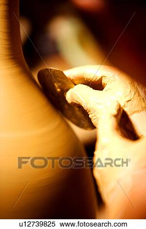 Stock Photography - Potter polishing clay body, close up of hand. Fotosearch
