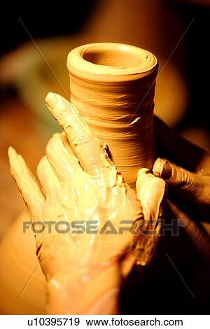 Stock Photo - Potter shaping mouth of pottery, focus on hands. Fotosearch