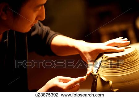 Stock Image - Potter trimming clay body. Fotosearch