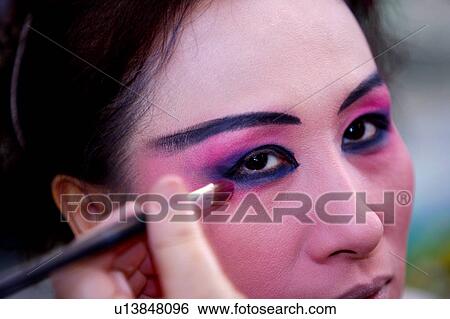 Makeup artists applying makeup to performer's eyes View Large Photo Image Stock Photograph - Makeup artists applying makeup to performer's eyes. Fotosearch