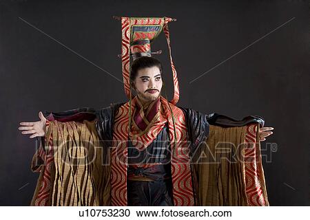 Stock Image - Mature man wearing traditional clothing with arms outstretched. Fotosearch